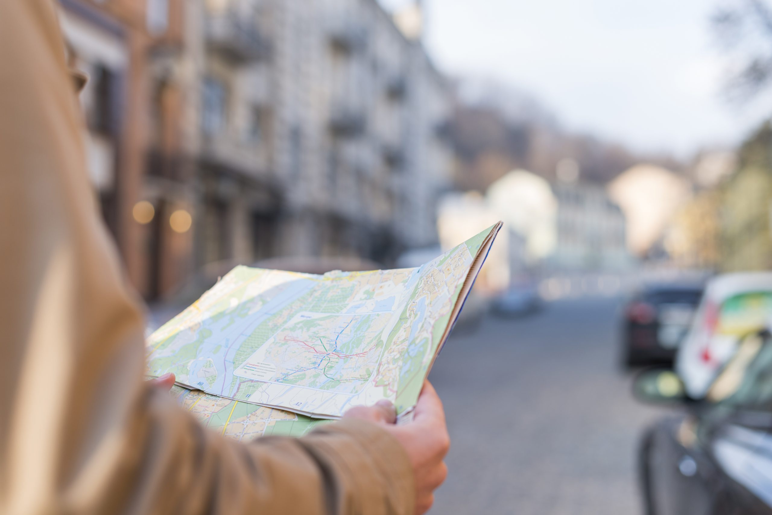 close-up-of-male-traveler-holding-map-in-hand-standing-on-city-street